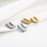 NOÉ gouden stainless steel oorbellen met rechthoekige vorm en zirkonia steentjes