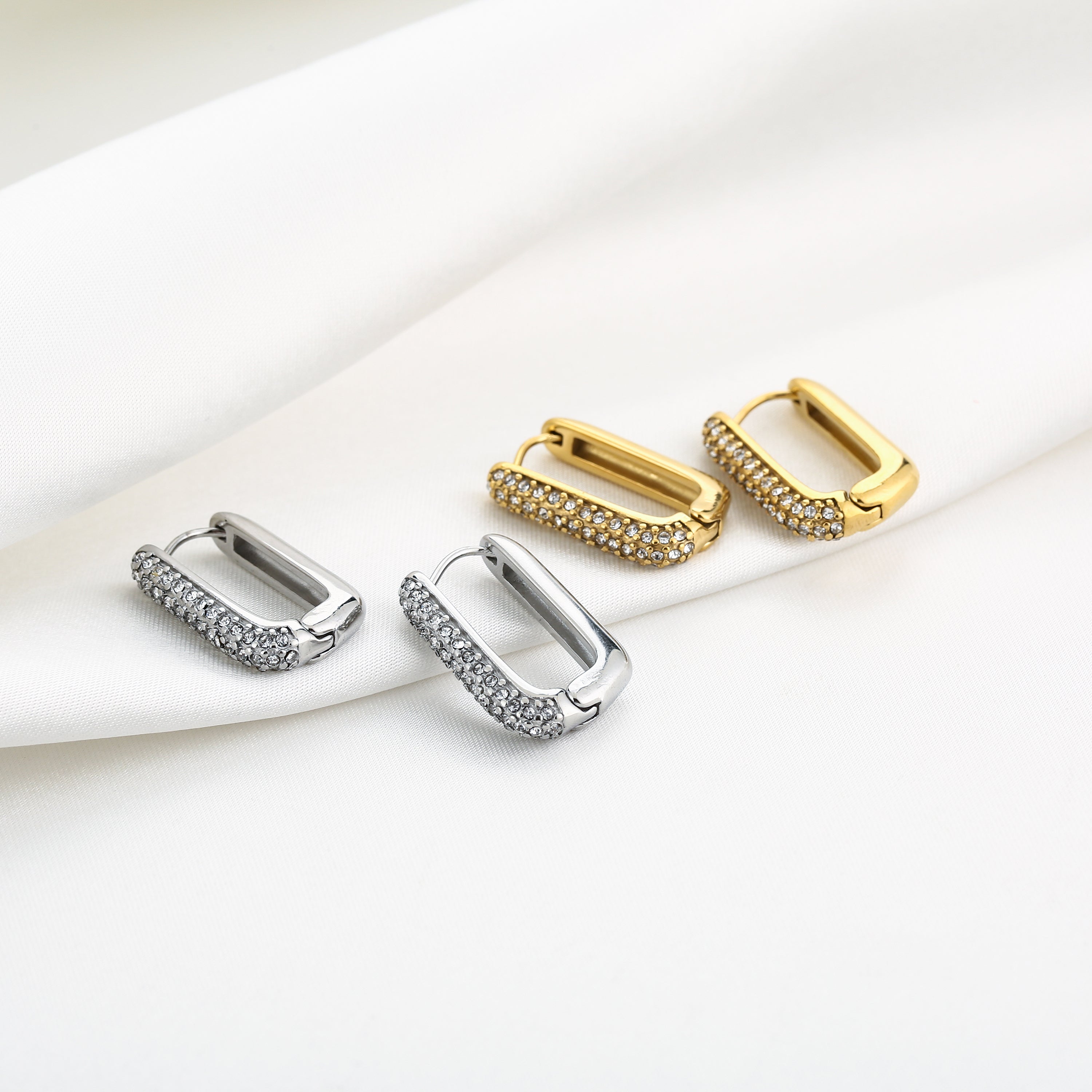NOÉ gouden stainless steel oorbellen met rechthoekige vorm en zirkonia steentjes